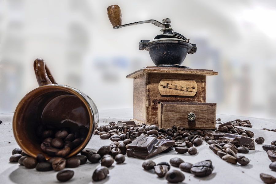 Spilled coffee beans and coffee grinder