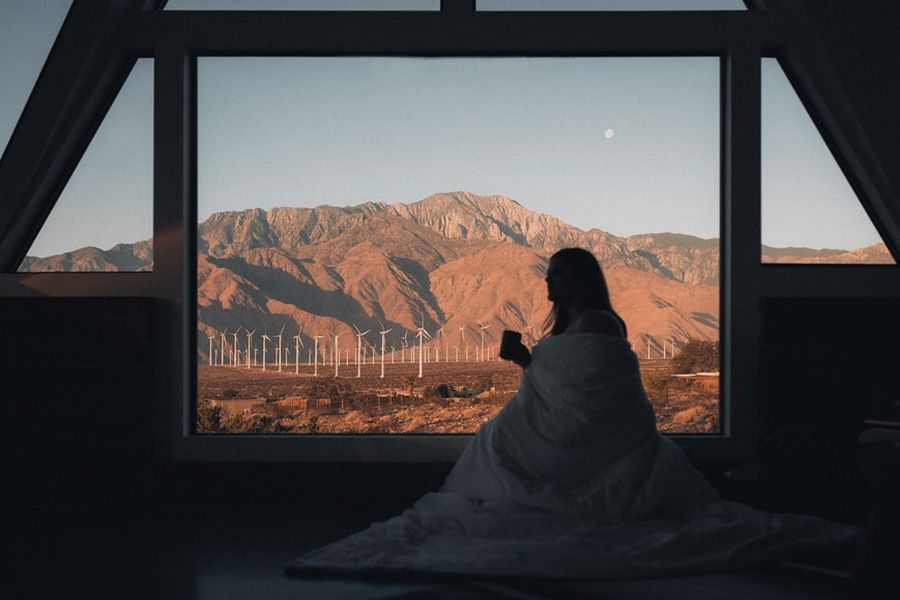 Woman drinking coffee while enjoying the view on her Airbnb