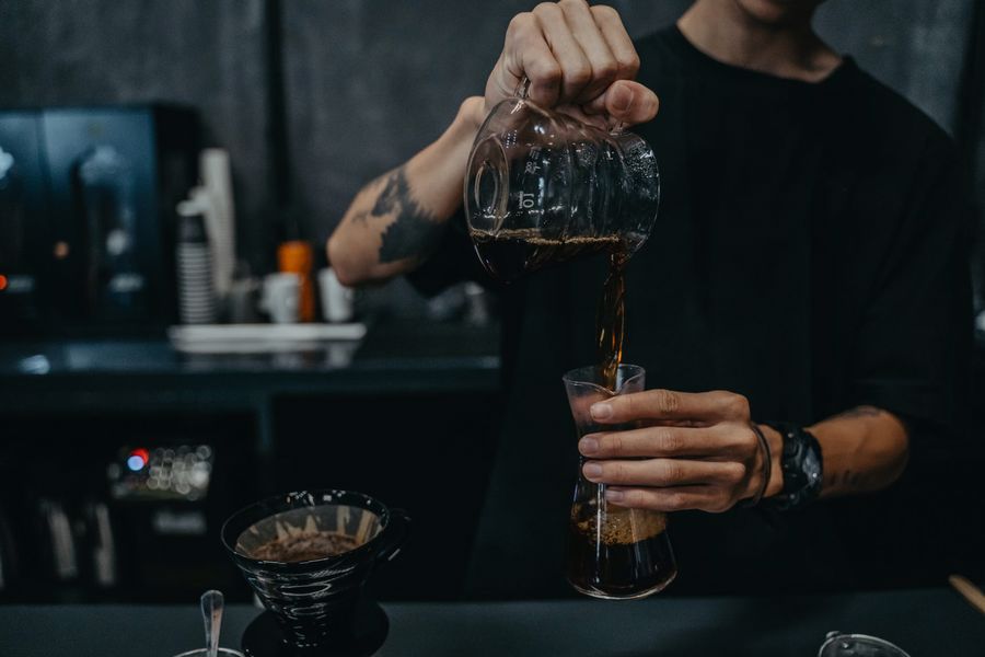 Barista pouring brewed decaf coffee