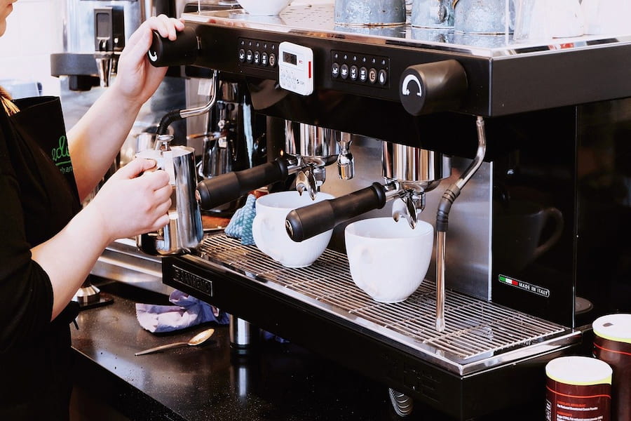 An image of a barista and a coffee maker