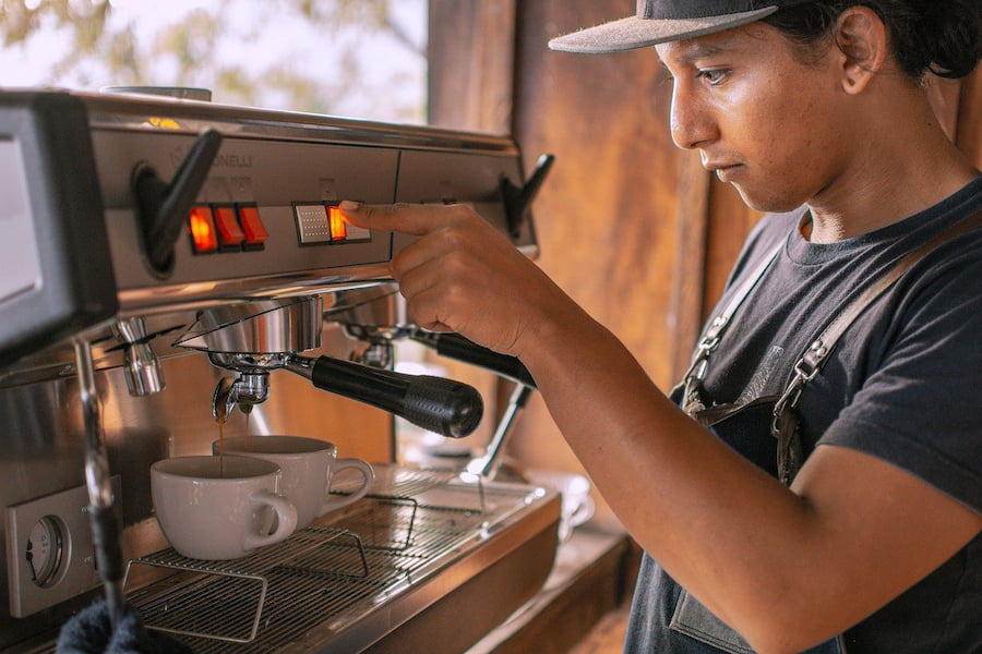 Barista making coffee in a coffee maker