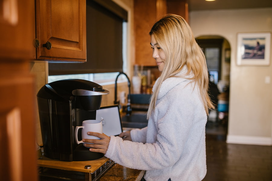 A woman trying out her black coffee maker