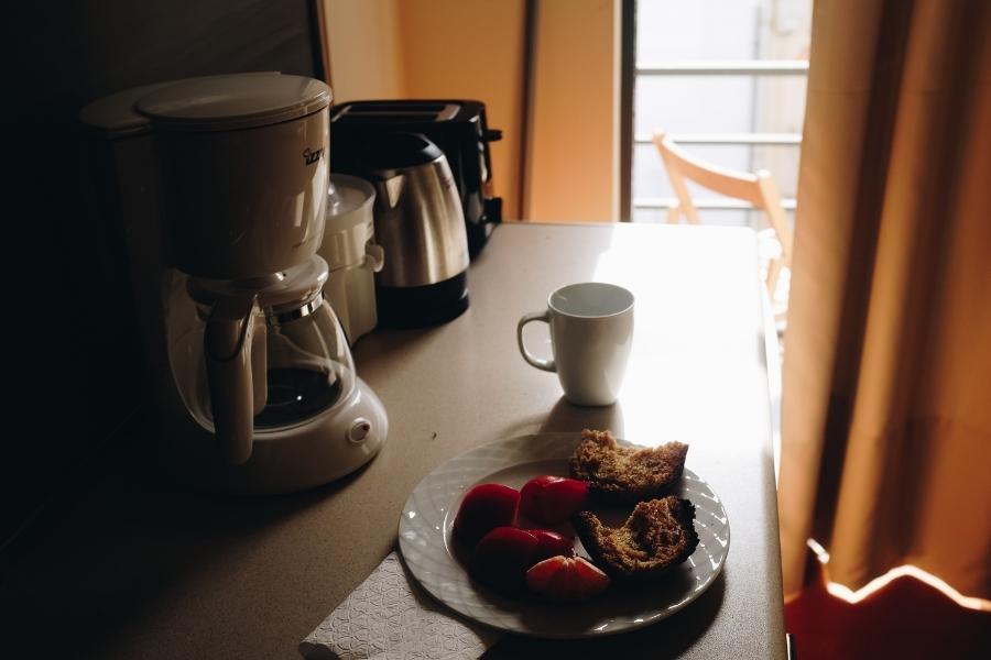 An image of a coffee maker and breakfast
