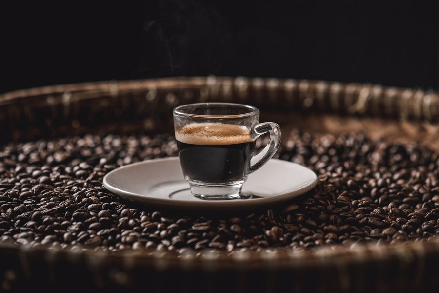 Coffee beans surrounding a cup of coffee