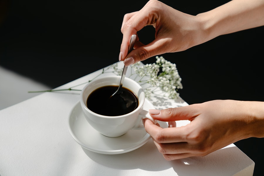 Person stirring her own coffee