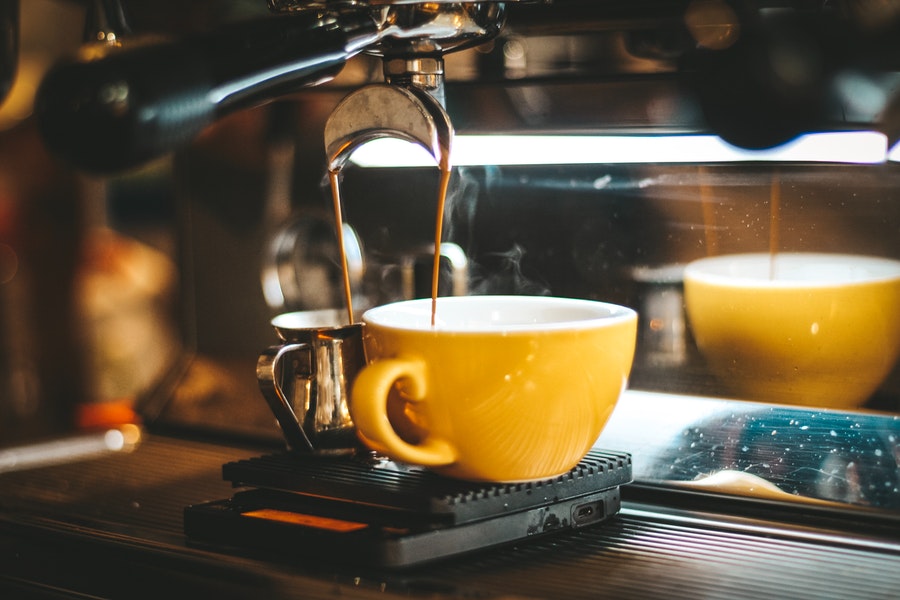 Coffee maker pouring coffee on cup