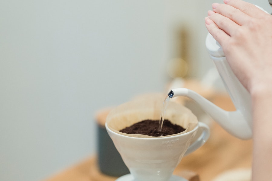 Pouring hot water in the coffee grounds with filter