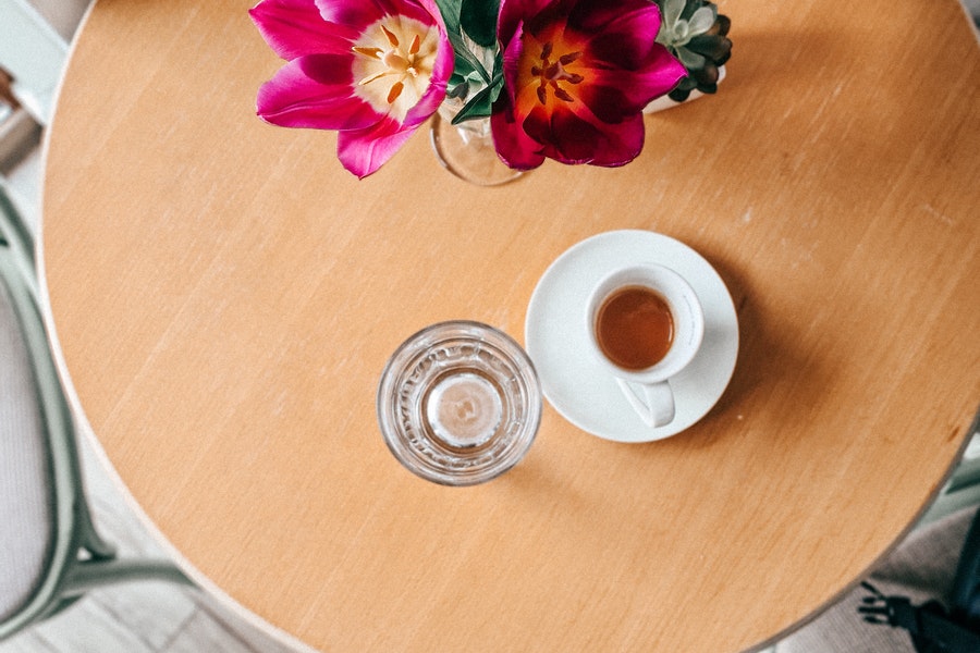 Coffee on the table with flowers and water