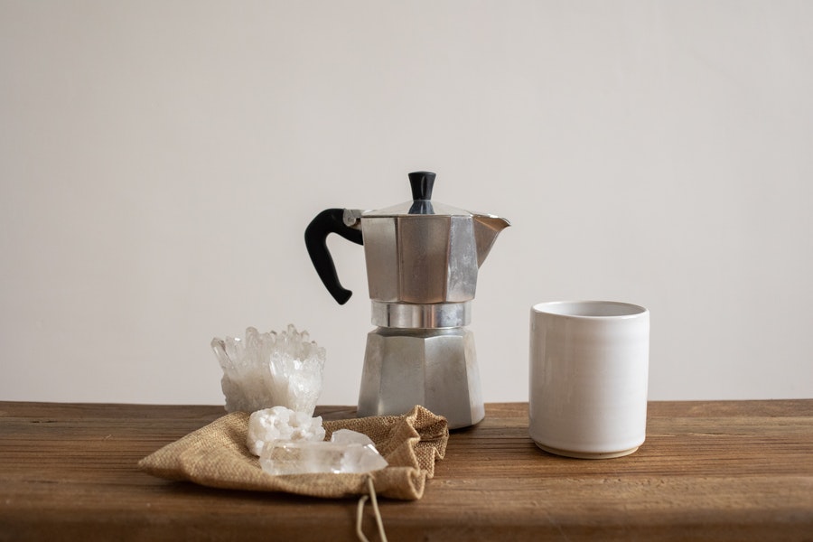 Moka pot on the table with a cup