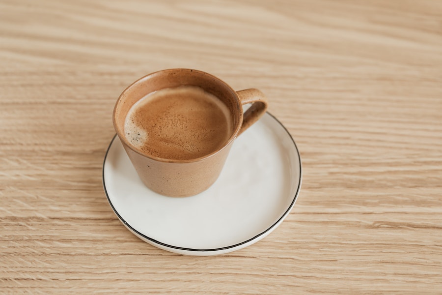 Coffee in mug placed in small plate