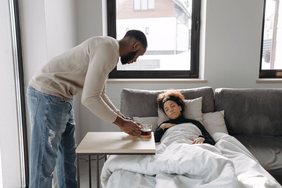 Husband taking care of his sick wife after drinking her cup of coffee