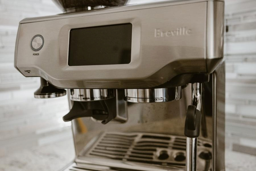 A close-up silver Breville coffee machine placed on a kitchen top