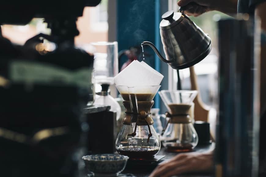 Hot water from the stainless kettle poured into a Chemex coffee maker