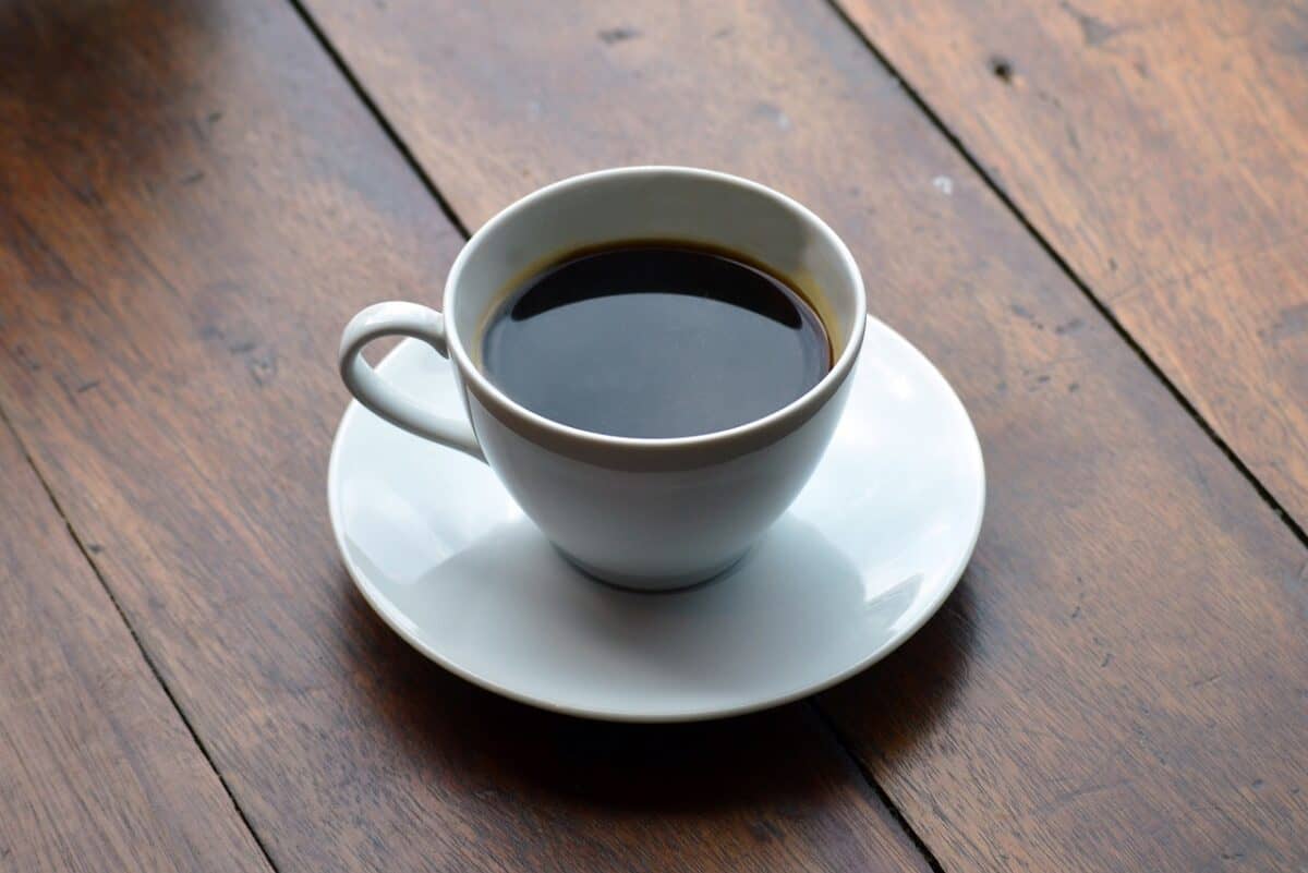 An Americano coffee in a white mug placed on a white saucer