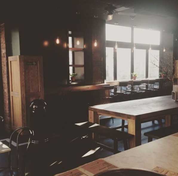 A coffee shop filled with wooden materials like chairs, tables, and cabinet