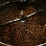 A close-up view of coffee beans being roasted on a coffee roaster