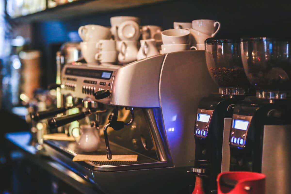 A silver espresso machine with different cups placed on top of it