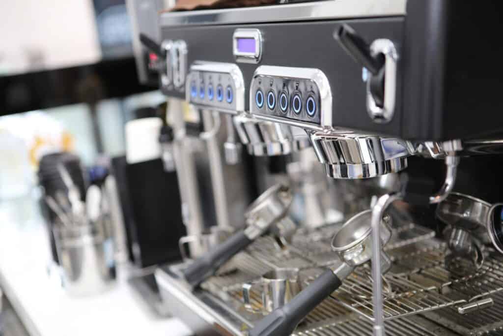 A silver metal coffee maker with several coffee settings sitting on a kitchen countertop